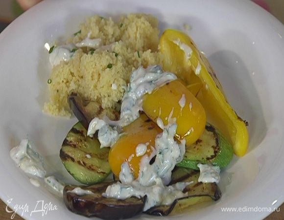 Обжаренные овощи выложить на тарелку с кускусом и полить соусом.