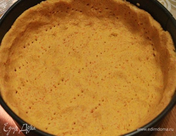 В разъемную форму диаметром 18 см выложить тесто. Наколоть вилкой и сверху на нее положить дежурную бобовую смесь. Запекать в духовке 12 минут.