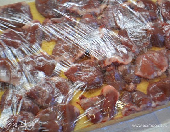 Сердечки помыть и обсушить бумажным полотенцем. Удалить лишний жир и сосуды. Разрезать вдоль не до конца и раскрыть, как книжку. Накрыть пищевой пленкой и слегка отбить.