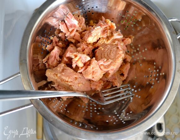 Первым делом консервированного тунца выложить в дуршлаг и дать стечь маслу. 