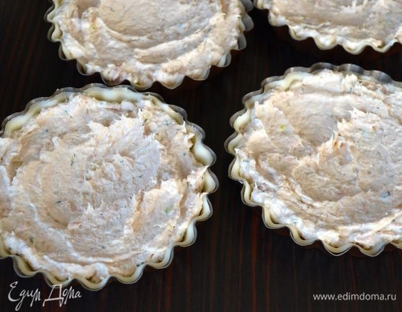 Выложить и распределить начинку по тарталеткам. В центре каждой тарталетки с помощью ложки, смоченной в воде, сделать небольшие углубления.