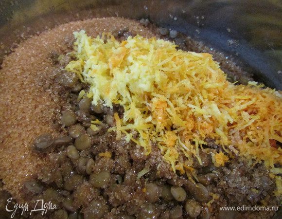 Через 40 минут к чечевице добавить имбирь, цедру цитрусовых, ванилин и коричневый сахар. Перемешать и варить еще 15 минут, обязательно помешивая. Оставить эту смесь на 6 часов или на ночь. Затем снова поставить на огонь, довести до кипения, пробить погружным блендером. Добавить какао, лимонный сок и орехи. Перемешать, довести до кипения и разложить по баночкам.