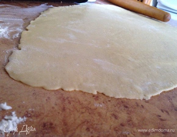 Затем тесто разделить на две части (можно не делить) и тонко раскатать (2-3 мм). Лучше раскатывать на пергаментной бумаге или с обратной стороны противня, присыпав предварительно мукой! Потому что его сложно потом переносить на противень, но я с помощью лопатки сделала это!)