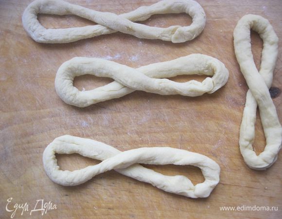 Вторую часть также разделить примерно на две части.
Эту 1/2 часть разделить на 4 кусочка, из которых скатать жгутики, длиной ~ 40 см.
Из них сделать такие четыре заготовки.