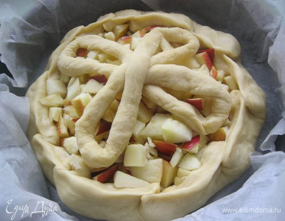 Края нижнего коржа загнуть и защипать.
Выложить поверх яблок заготовки.
