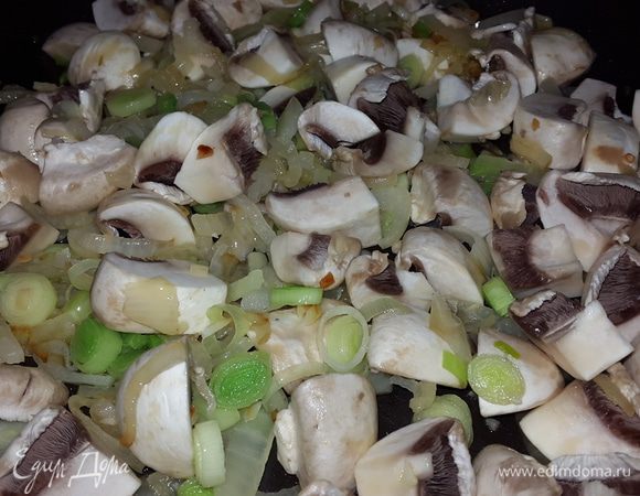 Отделяем шляпки шампиньонов, моем их и крупно режем. У меня были достаточно крупные грибы. Отправляем грибы к луку. Обжариваем на среднем огне до испарения жидкости.