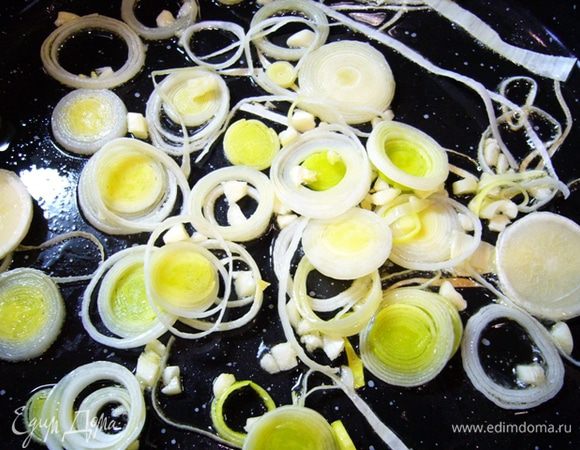 Кальмары очистить, вымыть, обсушить на бумажном полотенце.
Лук-порей нарезать колечками. Чеснок измельчить.
В сотейнике разогреть оливковое масло, обжарить лук с чесноком.
