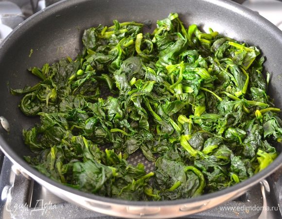 Тем временем займемся приготовлением начинки. Листья шпината вымыть, слегка стряхнуть воду и выложить листья шпината как есть на сковороду. При желании можно добавить полстакана воды, но, как правило, этого не требуется - для приготовления шпината хватит и той воды, что осталась на листьях. Накрыть сковороду крышкой и довести шпинат до готовности. Я по-прежнему советую вам не варить шпинат в воде, а готовить его именно таким "сухим" способом! При таком способе приготовления он лучшие сохраняет и свои вкусовые качества и свои полезные свойства. Готовый шпинат слегка остудить. 
