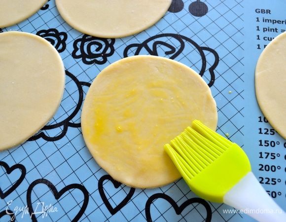 Яйцо слегка взбить в чашке (мисочке). Смазать первый диск из теста яйцом.