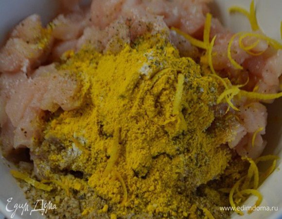 Куриное филе помыть, обсушить и мелко порубить. Добавить к нему куркуму, 1/2 часть чеснока через пресс, соль, перец, панировочные сухари, цедру и 2 ч.л холодной воды.