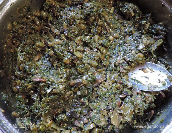 Первым делом займемся начинкой. 
Шампиньоны мелко нарезаем, выкладываем на раскаленную сухую сковороду, держим их там до испарения жидкости, затем уменьшаем огонь, добавляем растительное масло и мелконарезанный лук. Жарим до готовности лука. 
Затем добавляем на сковороду шпинат и обжариваем все вместе. Я шпинат разморозила заранее, хотя этого можно и не делать. 
Добавляем по желанию приправу, у меня сухая смесь "Итальянские травы", солим по вкусу. 

