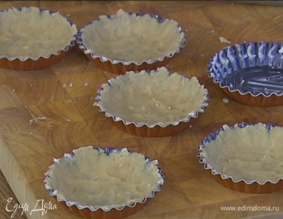 Небольшие формы для выпечки смазать оставшимся сливочным маслом и равномерно распределить тесто по дну и стенкам, сформировав бортики. Часто наколоть тесто вилкой и отправить в морозильник.