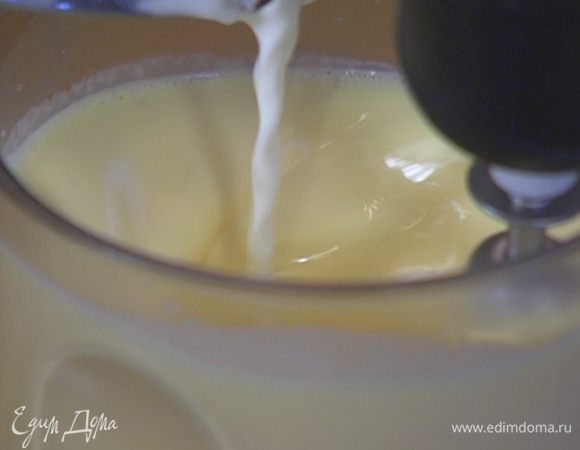 Продолжая взбивать на медленной скорости, тонкой струйкой влить горячее молоко со сливками.