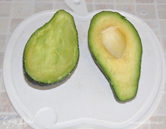 Пока запекаются рулеты – приготовим соус. Авокадо помыть, ложкой вынуть косточку. Сбрызнуть мякоть лимонным соком, чтобы она не потемнела. Чайной ложкой вынуть мякоть, стараясь не повредить шкурку – это будет наша соусница. 