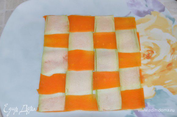 Сервируем наше блюдо. На большой тарелке выложить полосы кабачка и моркови и переплести их, как на фото. Выступающие края подрезать, чтобы получился квадрат.