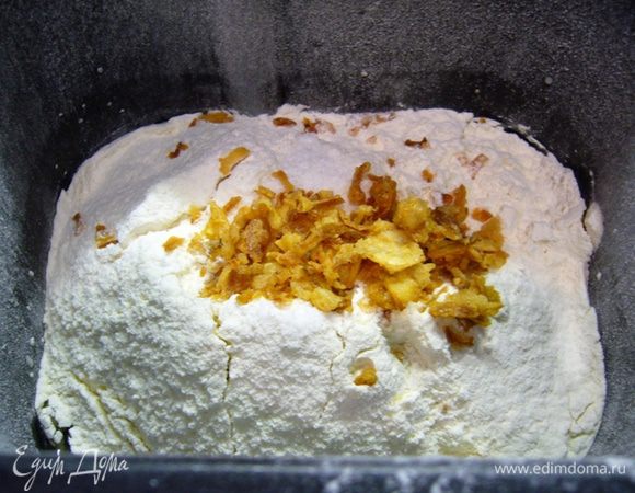 Воду нужно взять теплую. Налить ее в ведерко хлебопечки, добавить дрожжи, распустить их. Дать постоять 10 мин.
Добавить сахар, оливковое масло, просеять муку, засыпать соль и сушеный жаренный лук.
