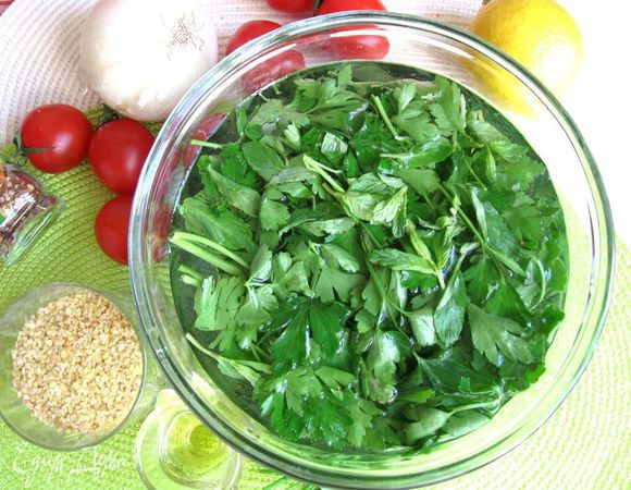 Петрушку, мяту, стебли шнитт-лука (зелени должно быть много, но пропорционально) положить в воду минут  на 15 минут, чтобы зелень  восполнила утраченную жидкость. Это  требуется сделать, если зелень не с вашей грядки, а из магазина или с рынка.