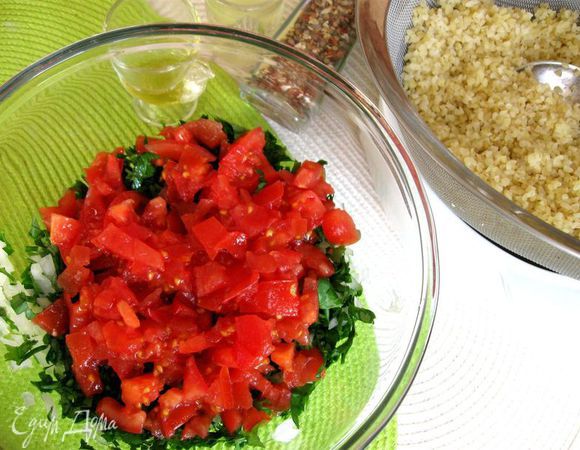 Нижним слоем в миску положить зелень, белый лук, затем с помощью широкой лопатки  -  помидоры.