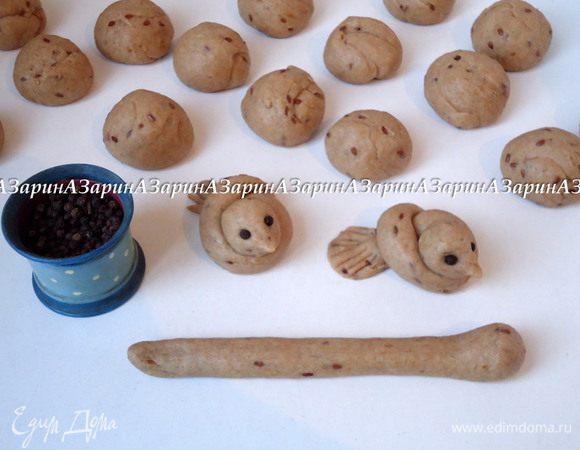 Из шариков сделать жгуты и завязать их в узелок, образуя голову и хвостик птички. На голове птицы пальцами образовать клюв. Вставить по две горошины перца, имитируя глаза. Хвост приплюснуть и сделать надрезы, имитирующие перья.