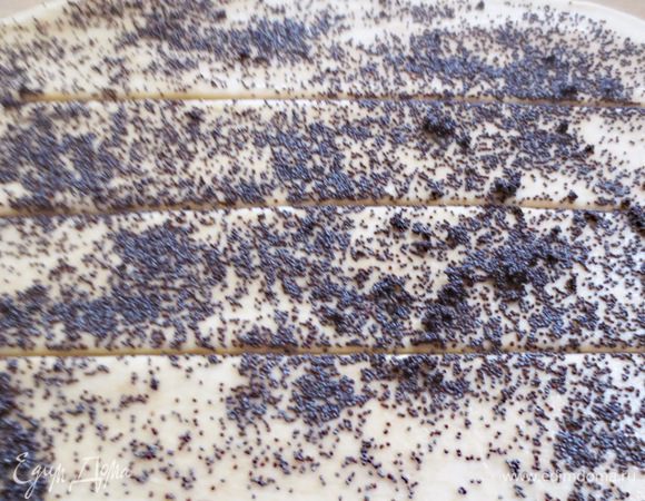 Равномерным слоем распределяем маковую  начинку. Разрезаем лист  на полоски, шириной примерно 5-6 см. 