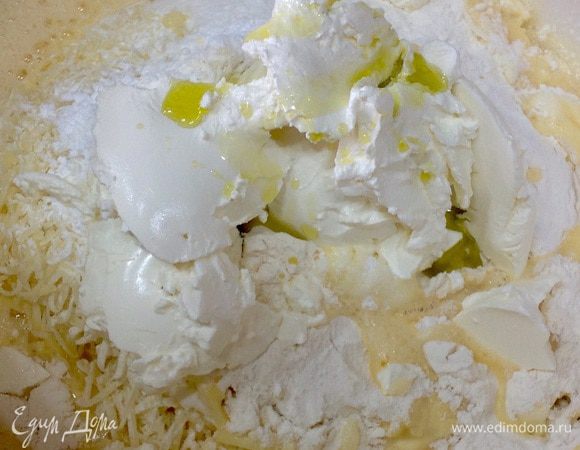 Массу из сыра и муки перемешать с яичной смесью. Добавить сметану и оливковое масло. Тщательно смешать. 