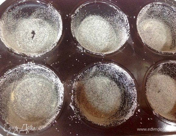 Формы для маффинов заранее смазать сливочным маслом и слегка присыпать манной крупой. 