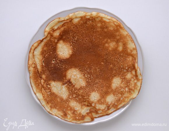 Выпечь блины, смазывая сковородку растительным маслом. Блинчики с кефиром получаются очень нежными, румяными.