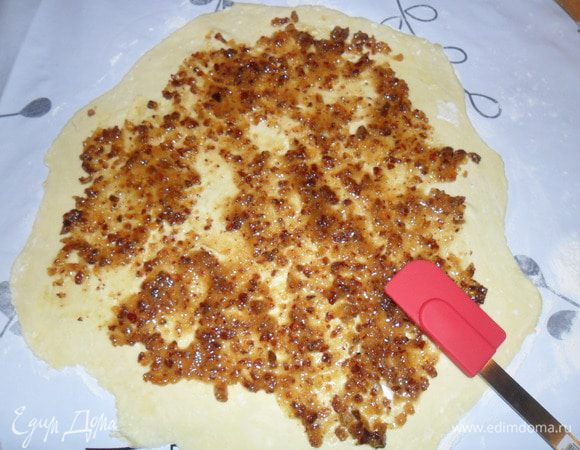 Поверхность присыпать мукой, раскатать корж и распределить начинку.