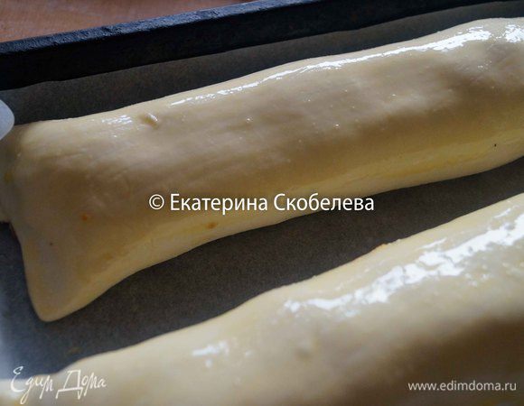 Свернуть тесто в рулет, выложить на противень застеленный бумагой для выпечки и смазать верх взбитым яйцом. Выпекать в разогретой до 180 градусов духовке около 40-45 минут.