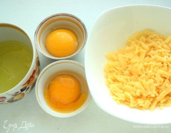 Яйца разделить на белки и желтки. Желательно, чтобы желтки остались целыми. Сыр натереть на терке.