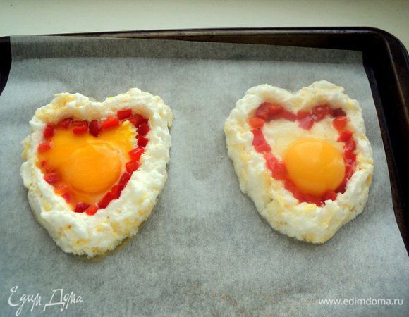 Красный перец порезать мелким кубиком и выложить по краю углубления в виде сердечка. Осторожно вылить по центру желток. У меня, к сожалению один желток растекся, но это не повлияло на вид и вкус блюда! Запекать в духовке при температуре 180 градусов 10-15 минут.
