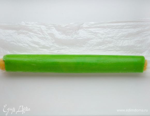 Свернуть рулетом. Завернуть в пищевую пленку и еще раз прокатать на столе рулет. Нужно положить его на разделочную доску и убрать в морозильную камеру на 3 минуты.