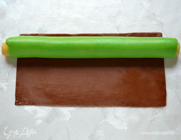 Выложить зеленый рулет и закатать его в коричневое тесто.