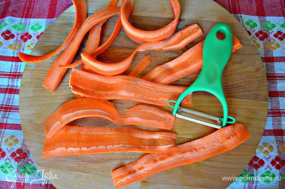 Очистить морковь и с помощью овощечистки нарезать тонкими лентами. Уложить морковь в миску и залить кипятком на 1-2 минуты.