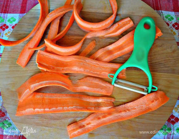 Очистить морковь и с помощью овощечистки нарезать тонкими лентами. Уложить морковь в миску и залить кипятком на 1-2 минуты. 