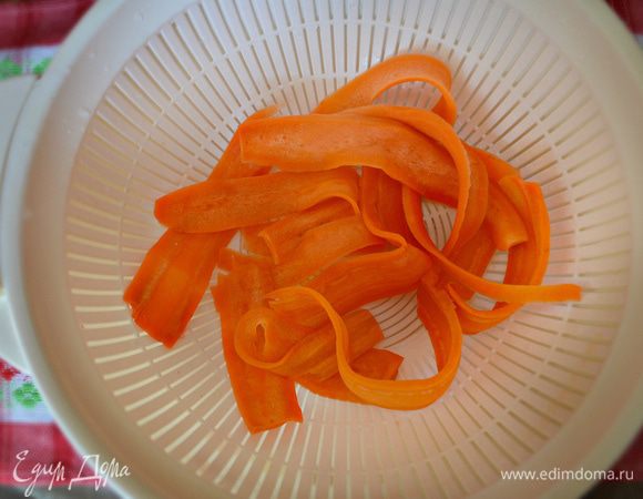 Затем слить горячую воду и залить ледяной водой, либо выложить морковные ленты на лёд.