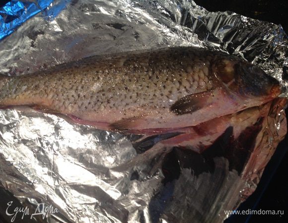 Духовку нагрейте до 180 градусов. Карпа почистите от чешуи, удалите жабры и потроха, промойте, обсушите бумажным полотенцем, натрите солью, перцем, смажьте маслом. Выложите на противень, предварительно застеленный фольгой.