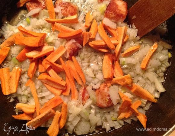 Тем временем чистим лук и морковь. Мелко режем лук, а морковь соломкой. Когда курица станет румяной, кладем туда лук и морковь. Добавляем перец и корицу, перемешиваем. Все это жарим, время от времени перемешивая.