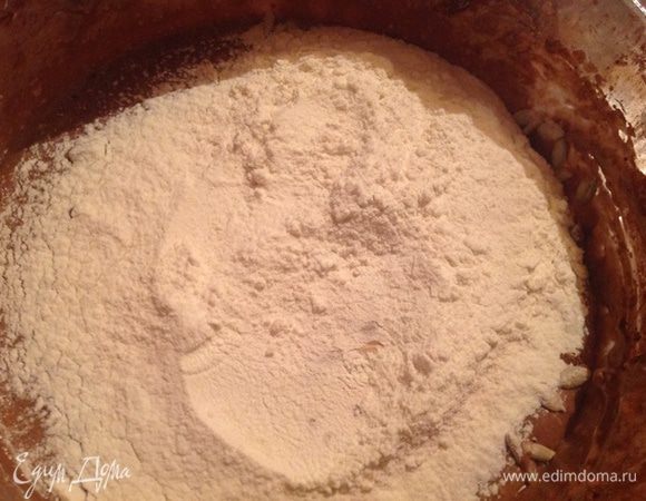 Сразу же над семечками не перемешивая посыпаем оставшуюся муку. Хорошенько все перемешиваем.