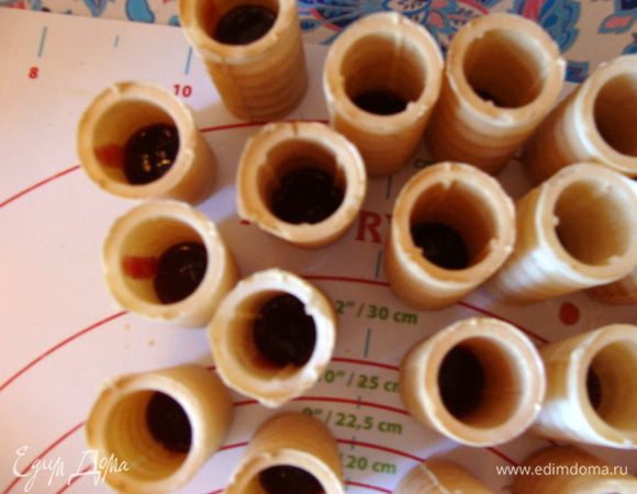 Две пачки по 38 г трубочек наполнить на 1/4 - 1/3 брусничным джемом.
Это лучше сделать заранее, чтобы потом сразу их выставить на корж или выставить на корж и потом наполнить джемом.