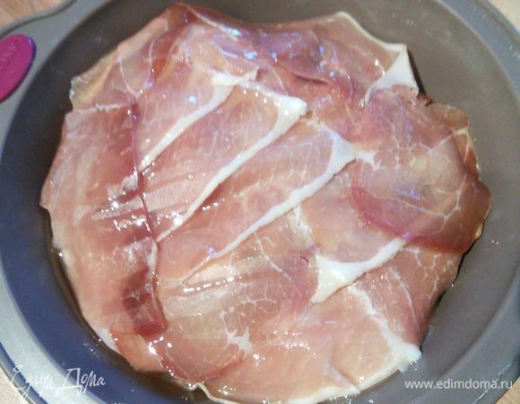 Разогрейте духовку до 200 °. Выложите ветчину внахлёст (кстати, ветчину можно вообще упустить, тогда сама шкурка запечётся), сбрызните оливковым маслом и запекайте в течении 40 мин. Последние 10 мин можно прикрыть фольгой. 