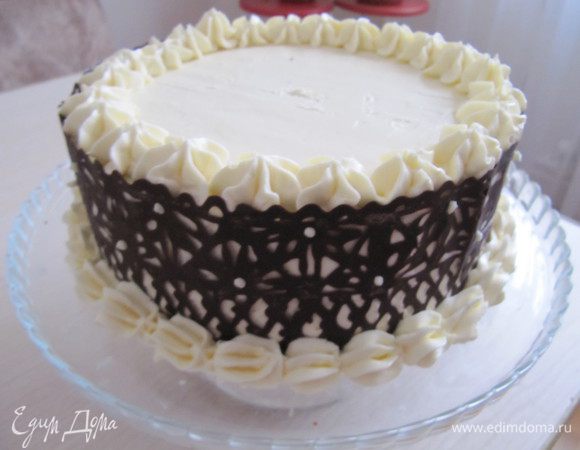 Оставшиеся сливочный крем положите в кондитерский мешок, украсьте торт по краю. Уберите осторожно бумагу с бока торта.