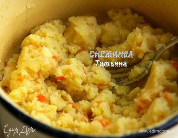 Продолжим готовить «колобки». Когда картофель и морковь сварились, сливаем воду и пюрируем овощи удобным для вас способом. Я воспользовалась толкушкой. Можно пропустить через мясорубку или использовать погружной блендер. Добавляем в горячее пюре соль по вкусу, молотый чёрный перец, мускатный орех и выдавленный через пресс чеснок. Хорошо перемешиваем.