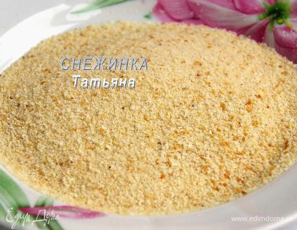 Насыпаем в тарелку панировочные сухари. Я сделала свои. Батон нарезала кубиками и подсушила в духовке. Затем измельчила в блендере.