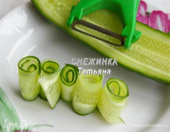 Огурец нарезаем на очень тонкие слайсы. Я воспользовалась овощечисткой. Сворачиваем в рулетики.