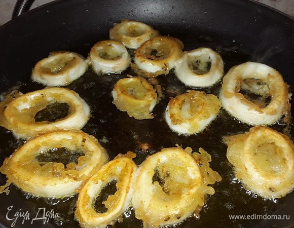 В сковороде хорошенько разогреваем оливковое масло и с помощью вилки выкладываем кальмары. Обжариваем партиями с обеих сторон до румяной корочки. 
