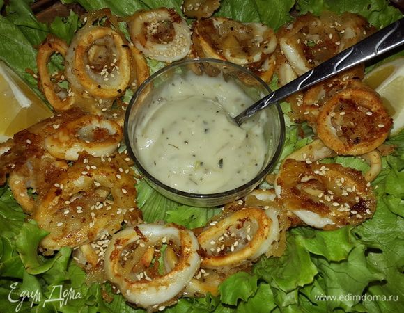 На большое блюдо выкладываем листья салата, по центру ставим соус, а вокруг выкладываем кольца кальмаров, подаем к столу. 

Приятного аппетита!