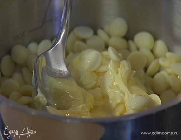 Белый шоколад и 100 г сливочного масла растопить в небольшой кастрюле на медленном огне, периодически перемешивая.