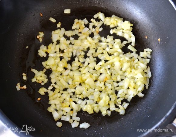 Духовку включить разогреваться на 190°C. 
В глубокой сковороде разогреть оливковое масло, слегка поджарить лук.