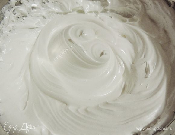Взбиваем белки до получения легкой пены. Добавляем лимонный сок и продолжаем взбивать до состояния, когда масса не выпадает из емкости при ее переворачивании.
Не прекращая взбивать, не менее чем за 10 приемов, добавляем сахар. Естественно он не растворится. Даже не пытайтесь этого добиться. Всыпали весь сахар - переходим к следующему этапу.
К этому времени на плите у нас уже кипит вода. Как только мы ввели всю норму сахара, ставим емкость с белками на водяную баню. Вода при этом должна еле кипеть. Взбиваем миксером ровно 10 минут.
Получаем вот такую пышную и очень густую массу.